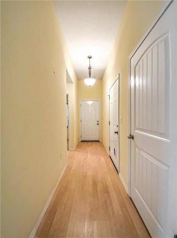 hallway with light wood-style floors and baseboards