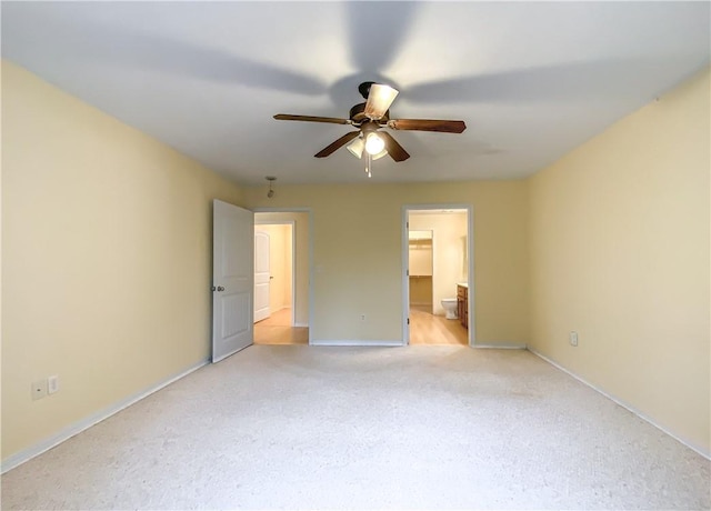 unfurnished bedroom featuring ceiling fan, baseboards, ensuite bath, and light colored carpet