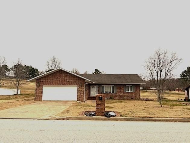 single story home featuring a garage and a front lawn