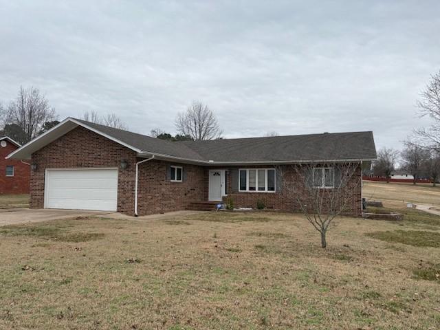 single story home featuring a garage and a front lawn