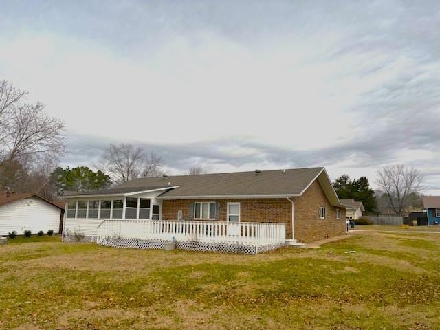 back of property featuring a wooden deck and a yard