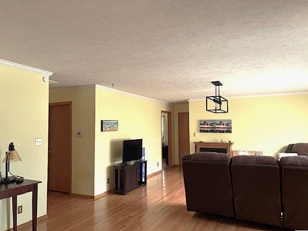 living room with crown molding, hardwood / wood-style floors, and a textured ceiling