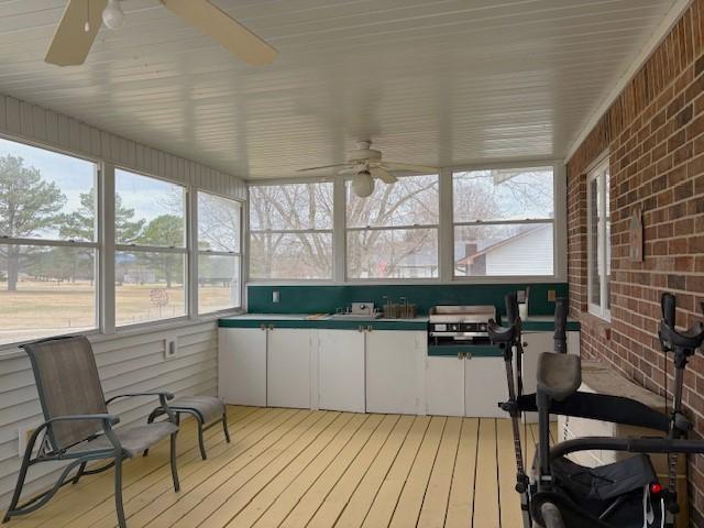 sunroom / solarium featuring a wealth of natural light and ceiling fan