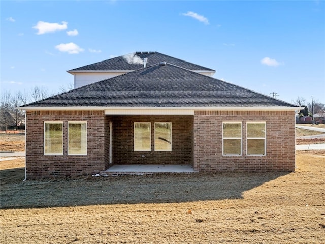 back of property with a yard and a patio area