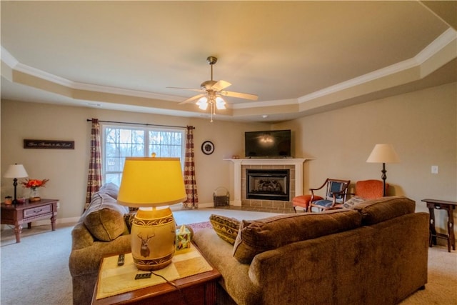 13 Smart Ln, Bella Vista, AR 72715 - living room featuring a tray ceiling, light colored carpet, ornamental molding, a ceiling fan, and a fireplace