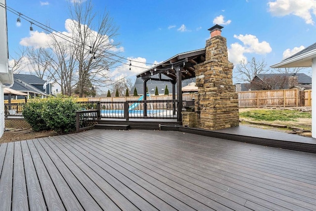 wooden terrace with a fenced backyard and a swimming pool