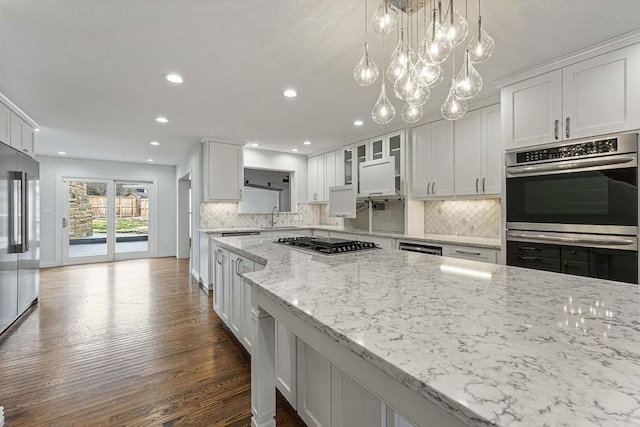 kitchen featuring dark wood-style floors, stainless steel appliances, a sink, and white cabinetry