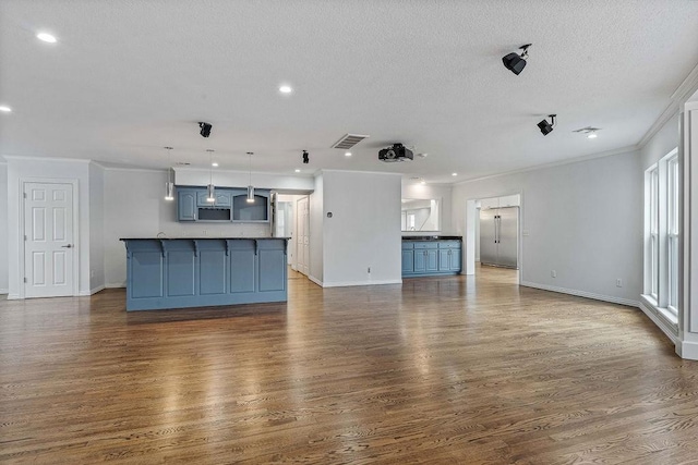unfurnished living room featuring crown molding, baseboards, dark wood finished floors, and a textured ceiling