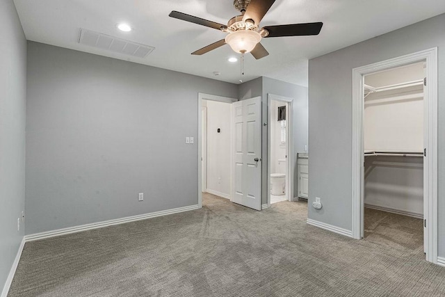 unfurnished bedroom featuring baseboards, a spacious closet, visible vents, and carpet flooring