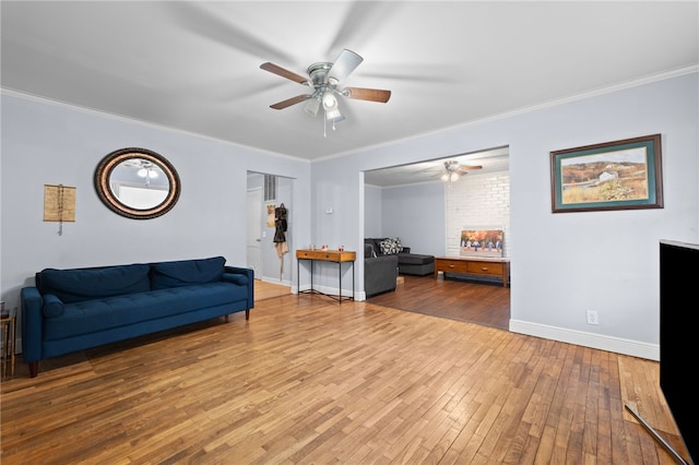 living room with hardwood / wood-style floors, ornamental molding, and ceiling fan