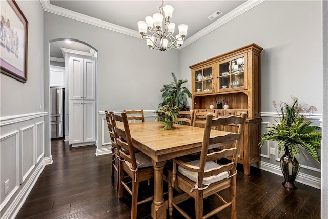 dining area with dark hardwood / wood-style flooring, crown molding, and a chandelier