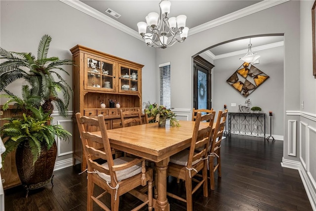 dining area with a notable chandelier, ornamental molding, and dark hardwood / wood-style floors