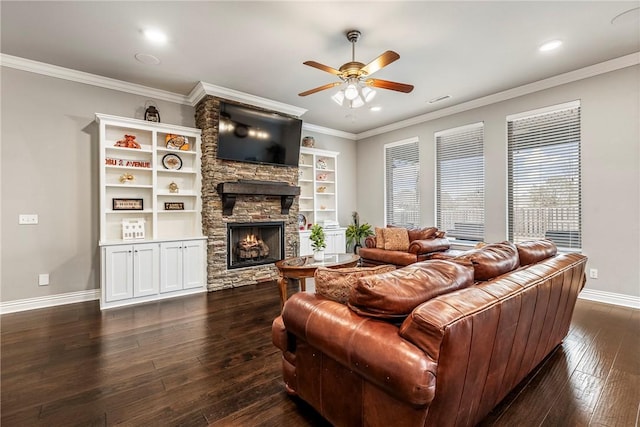 living room with a fireplace, ornamental molding, dark hardwood / wood-style floors, and ceiling fan