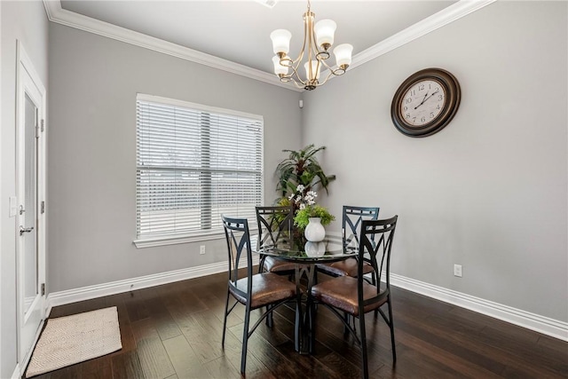 dining space with dark wood-type flooring, ornamental molding, and a chandelier