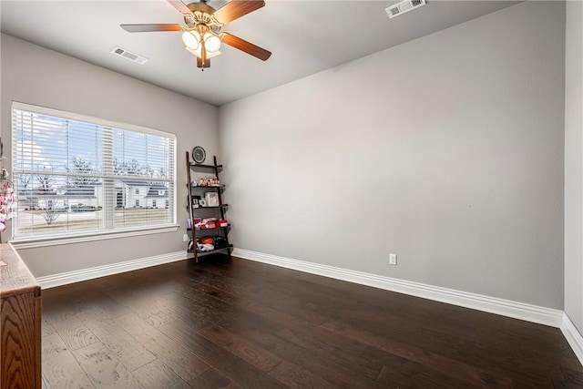 spare room with dark wood-type flooring and ceiling fan