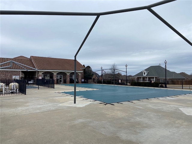 view of swimming pool featuring glass enclosure and a patio area