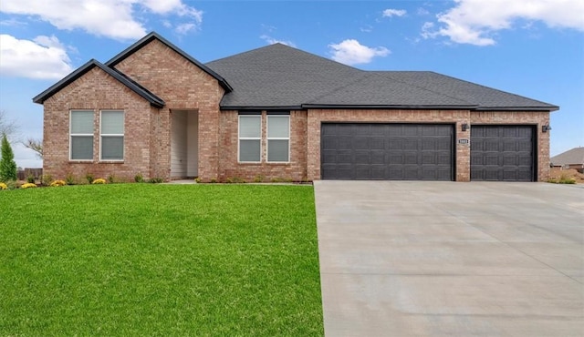 view of front of property featuring a front lawn, roof with shingles, concrete driveway, a garage, and brick siding