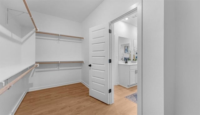 spacious closet with sink and light wood-type flooring