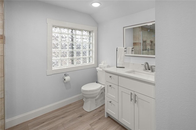 bathroom featuring lofted ceiling, toilet, a shower, wood-type flooring, and vanity