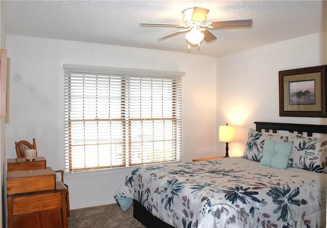 carpeted bedroom featuring ceiling fan and a textured ceiling