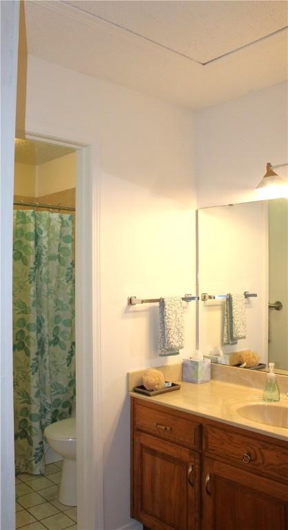 bathroom featuring vanity, tile patterned floors, and toilet