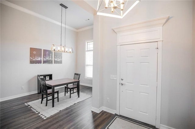 foyer entrance with crown molding, dark hardwood / wood-style floors, and an inviting chandelier