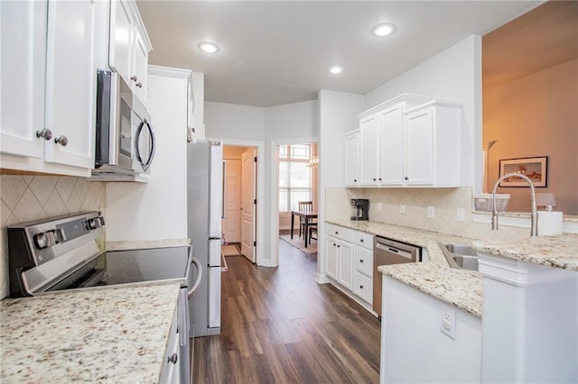 kitchen with sink, appliances with stainless steel finishes, white cabinetry, dark hardwood / wood-style floors, and light stone counters