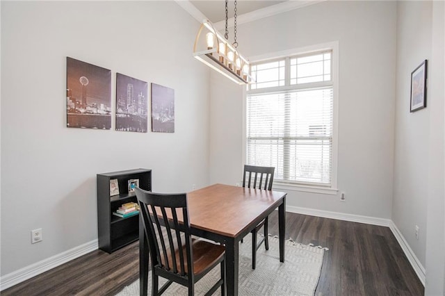 dining area with an inviting chandelier, dark wood-type flooring, and ornamental molding