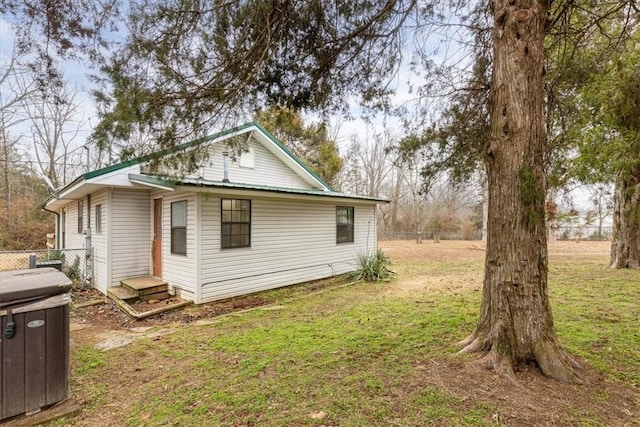 view of side of home with a yard