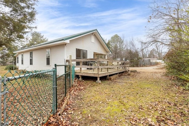 view of property exterior with a wooden deck and a yard