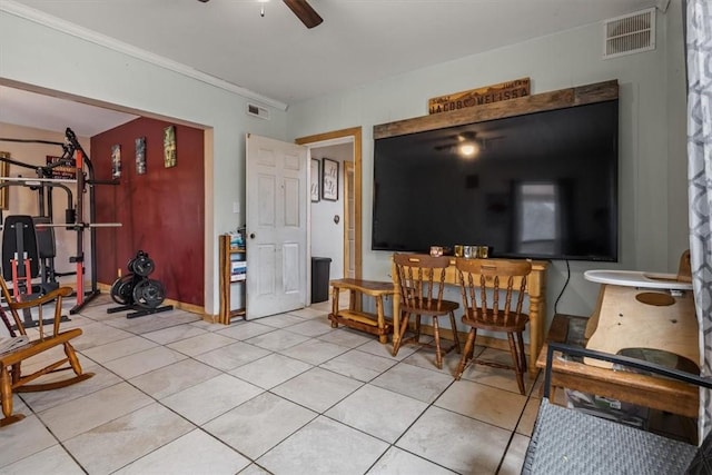 interior space with light tile patterned floors, crown molding, and ceiling fan