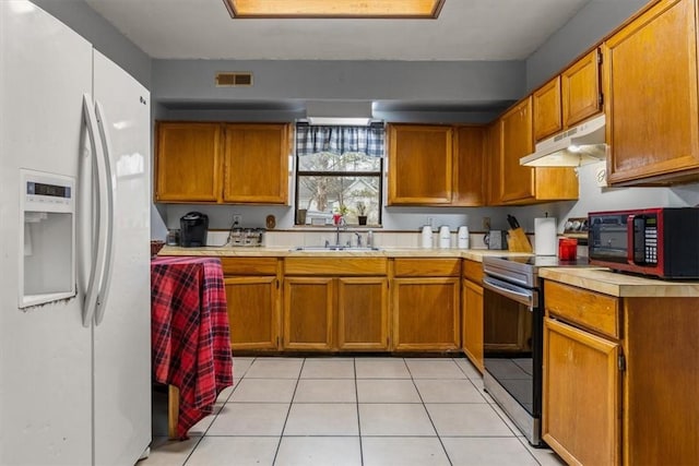 kitchen with stainless steel range with electric stovetop, sink, white refrigerator with ice dispenser, and light tile patterned flooring