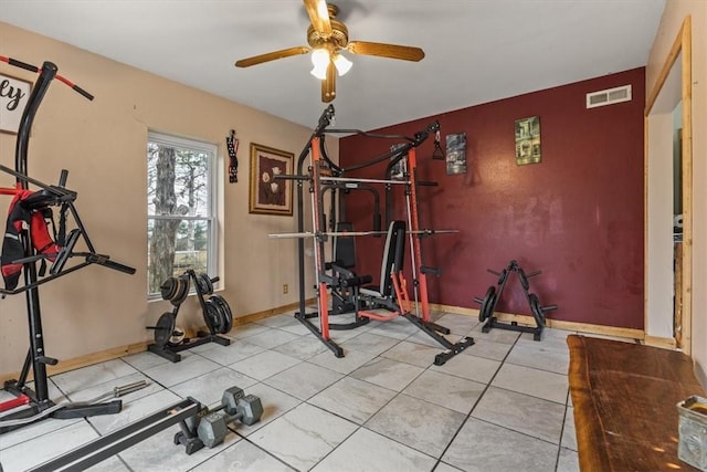 exercise area with tile patterned floors and ceiling fan