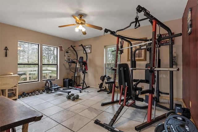 workout room with ceiling fan, light tile patterned floors, and a wealth of natural light