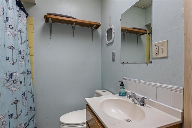 bathroom featuring vanity, curtained shower, and toilet