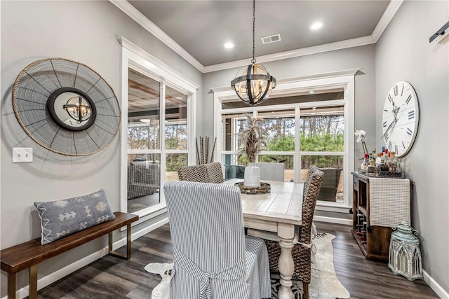 dining area with dark hardwood / wood-style flooring, crown molding, and a chandelier