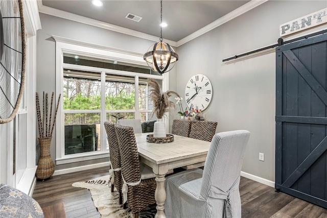 dining space with crown molding, a barn door, dark wood-type flooring, and a notable chandelier