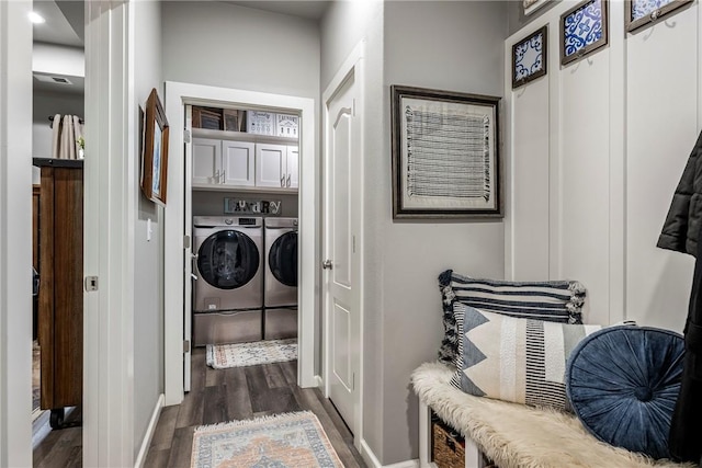 laundry area with cabinets, dark hardwood / wood-style floors, and washer and clothes dryer