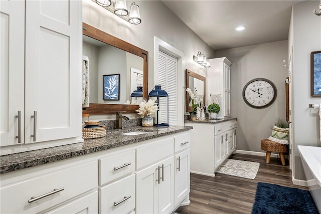 bathroom with vanity, a tub to relax in, and hardwood / wood-style flooring