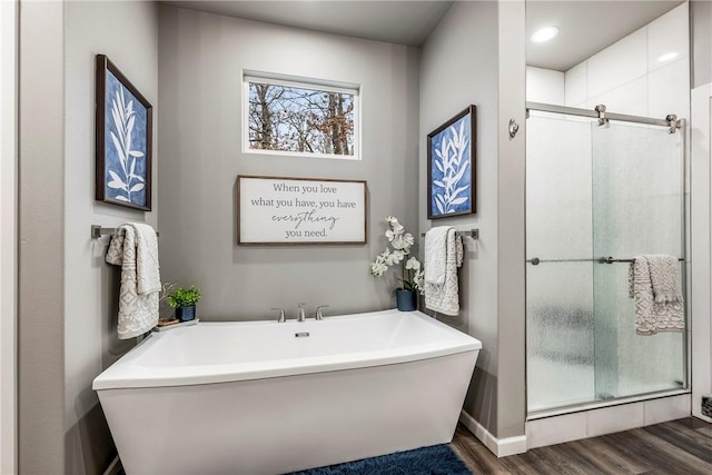 bathroom with wood-type flooring and plus walk in shower