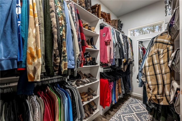 walk in closet with dark wood-type flooring