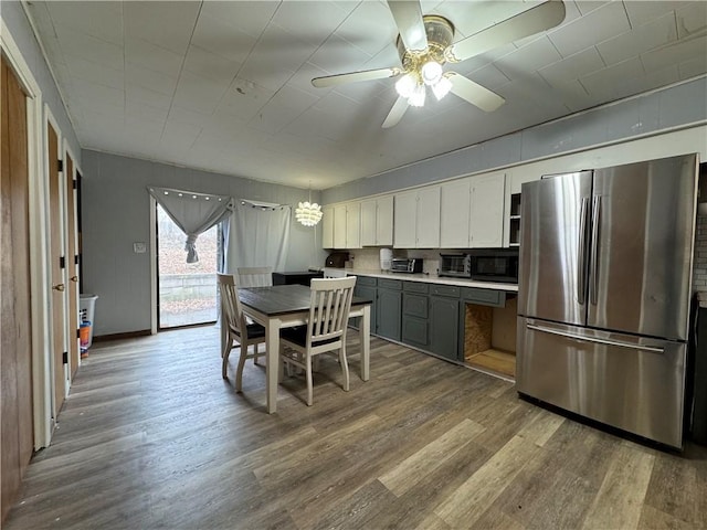 kitchen with light hardwood / wood-style flooring, ceiling fan, stainless steel fridge, and white cabinets