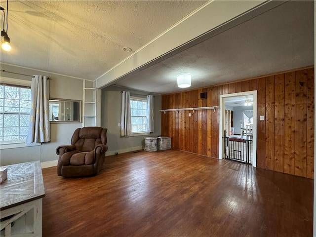 living area with hardwood / wood-style flooring, a textured ceiling, and wood walls