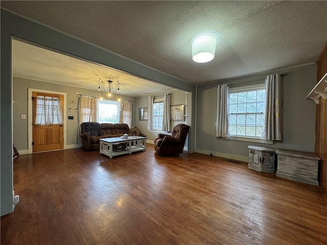 unfurnished living room featuring crown molding, dark hardwood / wood-style floors, and a textured ceiling