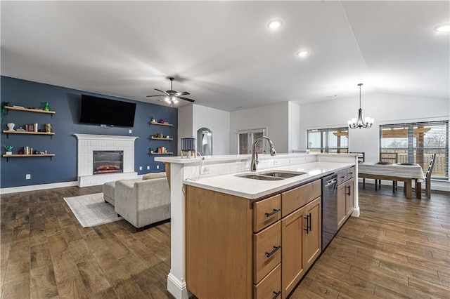 kitchen featuring dishwasher, dark wood-style flooring, light countertops, a brick fireplace, and a sink