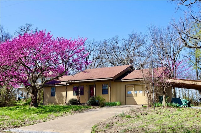 ranch-style house with a garage, a front yard, and a carport