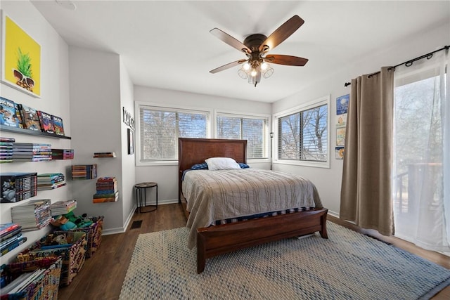 bedroom with dark hardwood / wood-style flooring, multiple windows, and ceiling fan