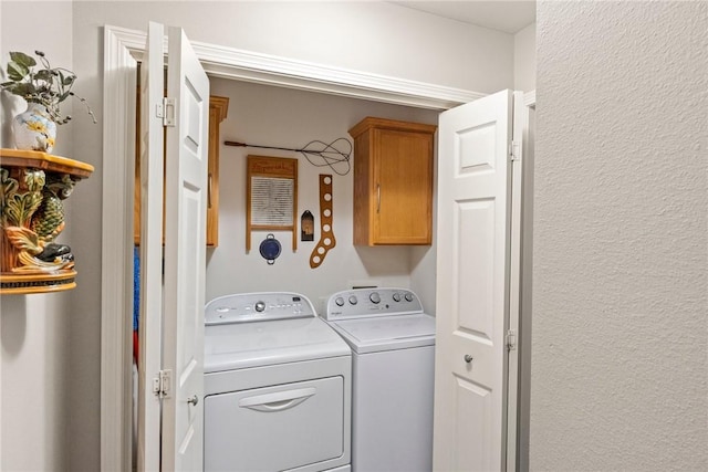 laundry room featuring cabinets and washing machine and dryer