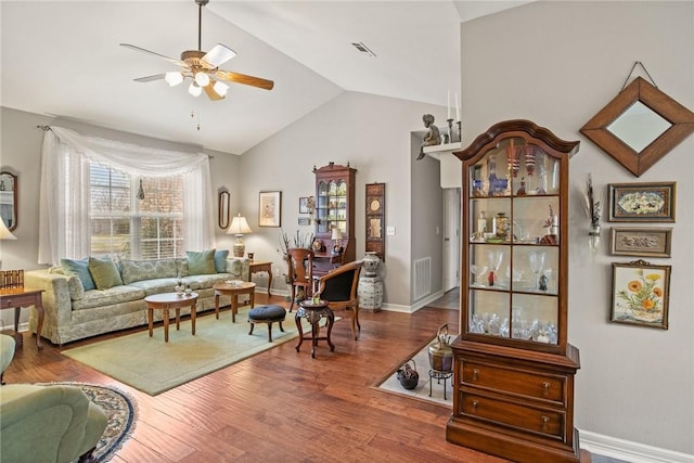 living room featuring hardwood / wood-style flooring, ceiling fan, and vaulted ceiling