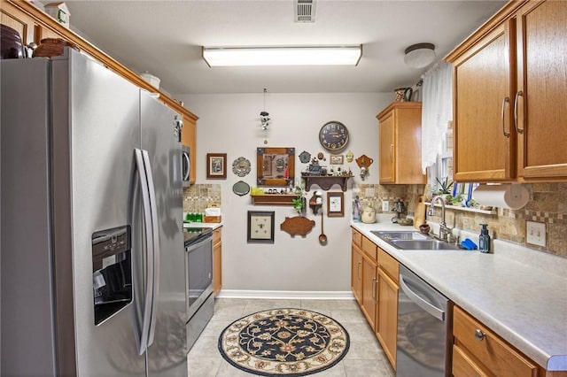 kitchen with sink, backsplash, stainless steel appliances, and light tile patterned floors